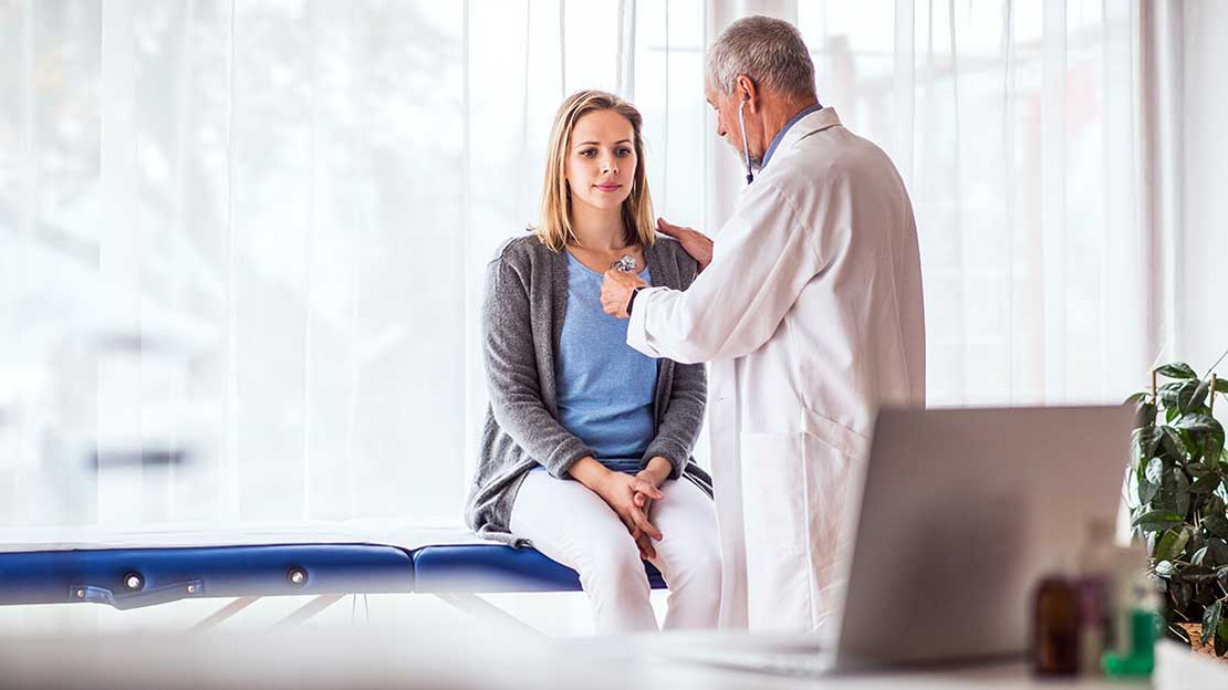 Arzt untersucht eine Patientin.